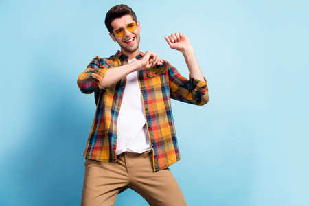 Portrait of attractive cheerful carefree guy dancing having fun good mood resting isolated over...