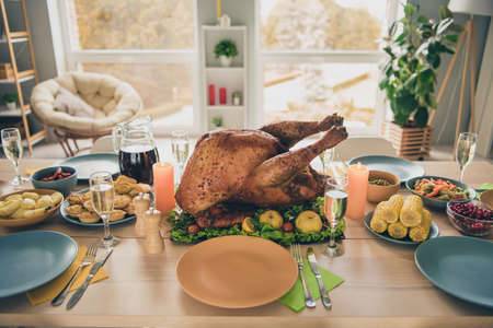 Photo of huge tasty roasted turkey standing holiday table waiting big family gathering indoors room homeの写真素材