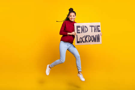 Full length body size photo woman jumping placard crazy end lockdown isolated vibrant blue color backgroundの写真素材