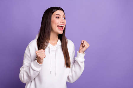 Photo of happy cheerful positive woman look empty space winner celebrate isolated on purple color backgroundの写真素材