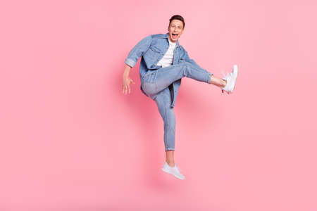 Full size photo of young smiling good mood male jumping dancing in air careless isolated on pink...