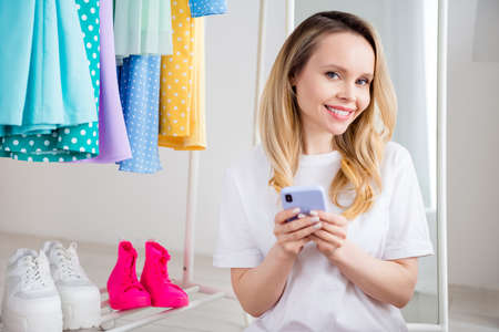 Photo portrait woman buying clothes in shopping center browsing internet with smartphone smilingの写真素材