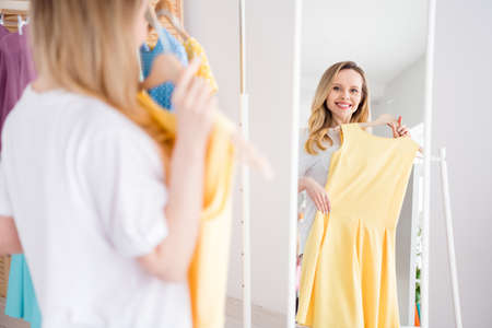 Photo portrait woman choosing dress in boutique fitting roomの写真素材