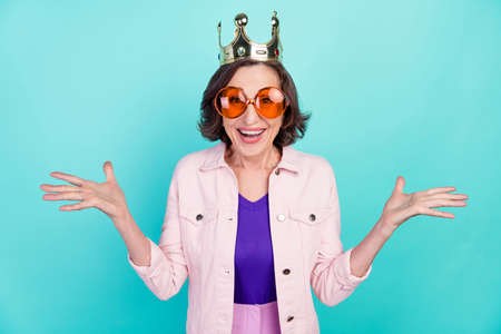 Photo portrait woman wearing golden crown sunglass smiling amazed surprised isolated vivid turquoise color backgroundの写真素材