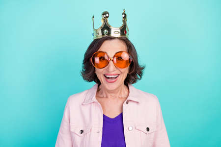 Photo portrait woman wearing golden crown sunglass smiling overjoyed isolated bright turquoise color backgroundの写真素材