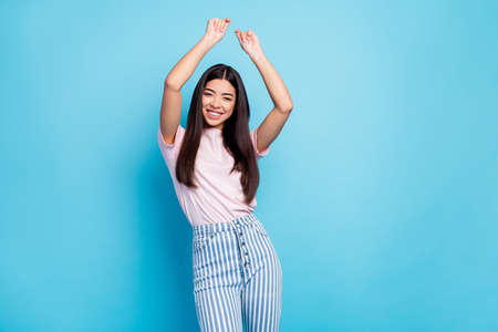 Photo of pretty cheerful brunette person raise hands toothy smile dancing isolated on blue color...