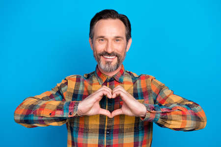 Photo of cool brunet hairdo age man hands heart wear plaid shirt isolated on blue color background