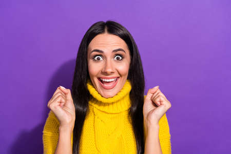 Portrait of delighted positive girl fists up scream yeah look camera cant believe isolated on purple color backgroundの写真素材