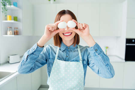 Photo portrait girl covering eyes with two eggs cooking omeletteの写真素材