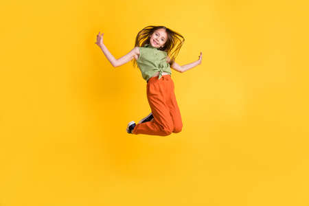 Full length body size photo little girl jumping up careless happy isolated vibrant yellow color backgroundの写真素材
