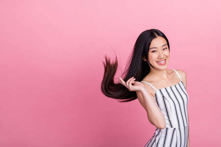 Photo of cute pretty young woman dressed white clothes smiling showing v-sign empty space isolated pink color backgroundの写真素材