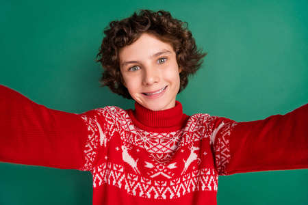 Photo of cheerful guy shoot selfie shiny white smile wear deer ornament sweater isolated green color backgroundの写真素材