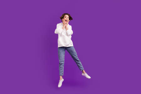 Full size photo of young good mood crazy amazed girl jump hear unexpected news isolated on violet...