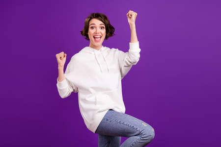 Photo portrait girl wearing hoody gesturing like winner isolated bright pastel color backgroundの写真素材