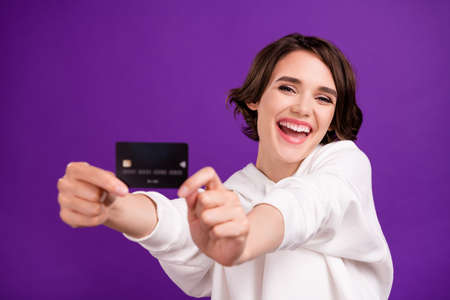 Photo portrait girl in sportswear showing plastic credit card laughing cheerful isolated bright pastel color backgroundの写真素材