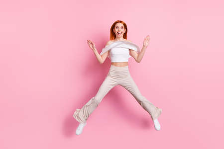 Full length body size view of attractive funky cheerful girl jumping having fun isolated over pink...