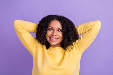 Photo of thoughtful pretty dark skin girl dressed sweatshirt arms behind head looking empty space isolated purple color backgroundの写真素材