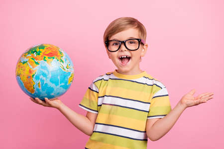 Photo of young small happy boy hold hands globe lesson glasses enjoy cool isolated on pink color backgroundの写真素材