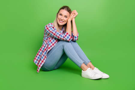 Full body profile side photo of young woman happy positive smile dream hands touch cheek isolated over green color backgroundの写真素材