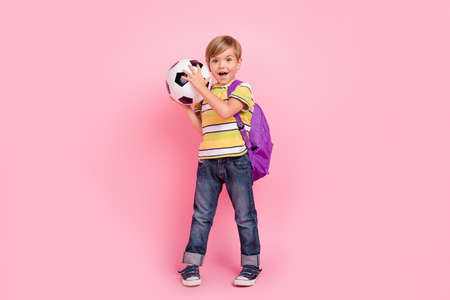 Full length photo of young small boy wear backpack hold hands football good mood isolated on pink color backgroundの写真素材