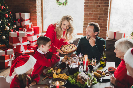 Photo of small little childhood grandchildren grandmother grandfather pensioner retired friends noel people dinner table xmas indoors houseの写真素材