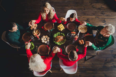 Top view photo portrait of full family praying before beginning xmas mealの写真素材