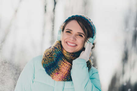 Photo of charming joyful attractive happy woman listen music good mood wear scarf outdoors in park outsideの写真素材