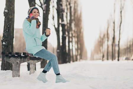 Full length profile side photo of charming attractive young lady hold phone talk coffee takeout sit...