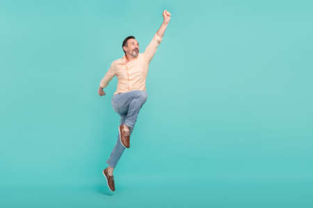 Full size photo of funny age man jump wear shirt jeans sneakers isolated on teal color background