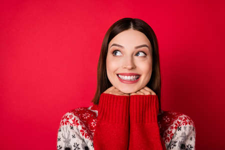 Photo of tricky charming young lady wear print sweater arms chin looking empty space isolated red color backgroundの写真素材