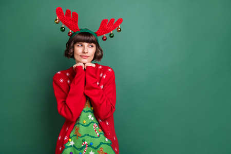 Portrait of attractive bewildered brown-haired girl thinking copy blank space isolated over green color backgroundの写真素材