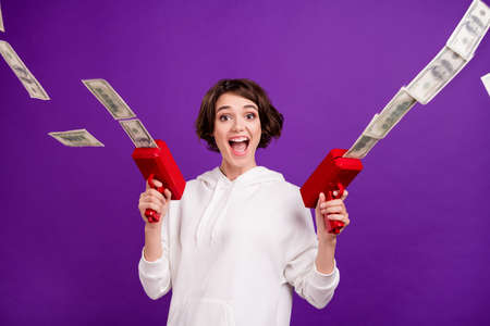 Photo portrait girl in sportswear shooting banknotes in air isolated vivid pastel color background