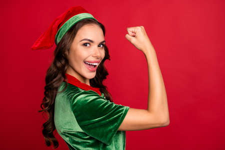Photo portrait woman in elf outfit showing strong biceps isolated bright red color backgroundの写真素材