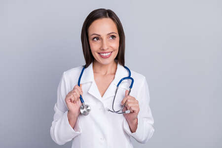 Photo of mature woman happy positive smile nurse assistance curious look empty space isolated over grey color backgroundの写真素材