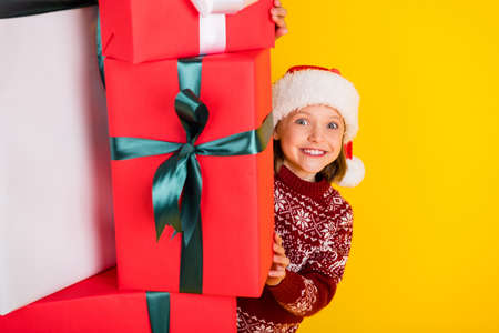 Photo of young girl happy positive smile gift atmosphere spirit tradition new year isolated over yellow color backgroundの写真素材