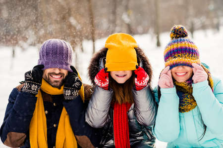 Photo of cheerful family happy positive smile have fun playful fooling close cover eyes hat outdoorsの写真素材
