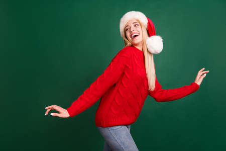 Photo portrait blonde woman in santa hat laughing dancing at party isolated green color background
