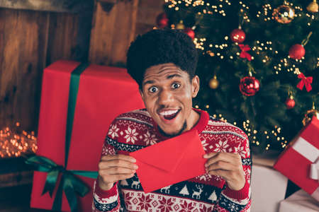 Photo portrait smiling excited man keeping letter for santa claus on xmas holidays having a wishの写真素材