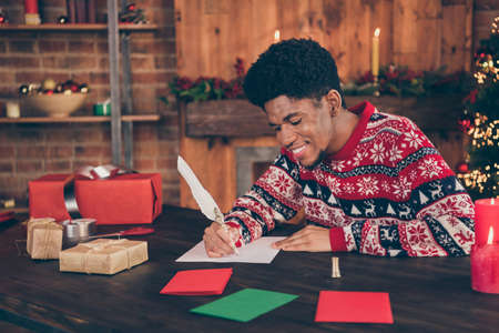 Photo portrait young man writing letter to santa claus on xmas winter holidays smiling happyの写真素材