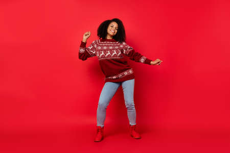 Full length body size photo woman smiling chilling dancing at xmas party isolated bright red color backgroundの写真素材