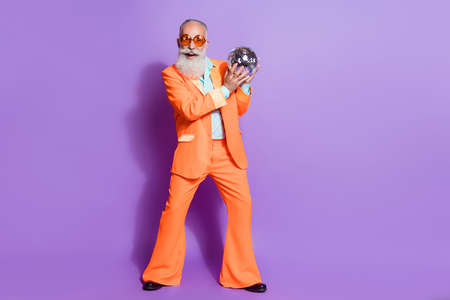 Full size photo of old funky happy man wear sunglass hold hand disco ball club isolated on purple color backgroundの写真素材