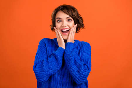 Portrait of attractive cheerful impressed girl having fun great news holiday isolated over vibrant orange color backgroundの写真素材