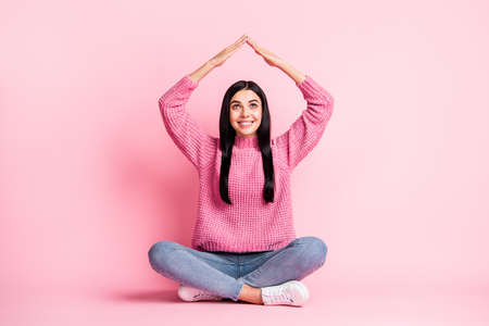 Full body photo of pretty person look arms make house figure above head isolated on pink color backgroundの写真素材