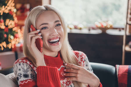 Portrait of attractive cheerful girl talking on phone laughing spending day eve time at decorated...