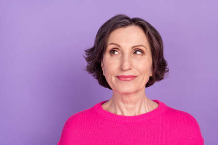Photo of aged woman happy positive dream curious look empty space isolated over violet color...