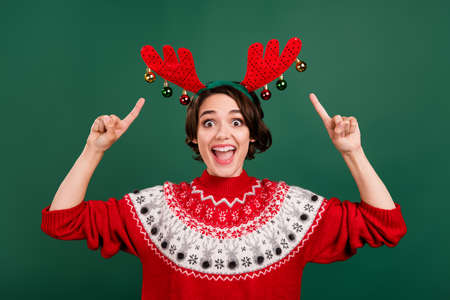 Portrait of attractive overjoyed cheerful girl demonstrating wearing festal look isolated over green...