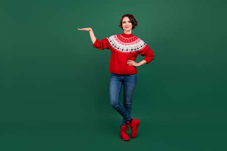 Full length body size view of attractive cheerful girl holding on palm copy space ad isolated over green color backgroundの写真素材