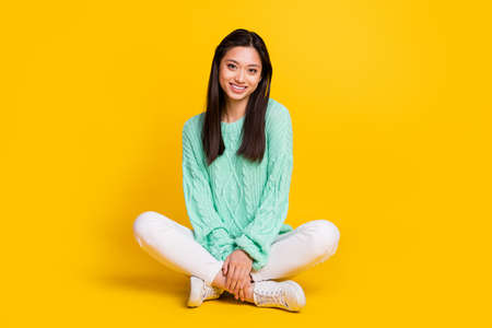 Full body photo of pretty cute nice woman sit floor good mood smile isolated on shine yellow color backgroundの写真素材