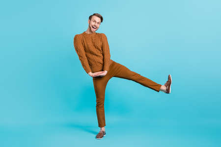 Full length photo of funky happy young man dance good mood smile isolated on blue color backgroundの写真素材