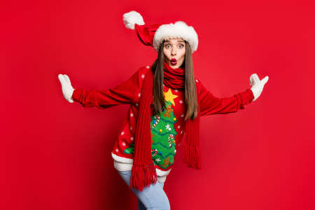 Photo of charming impressed young woman dressed ugly pullover scarf big eyes isolated red color backgroundの写真素材